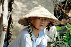 11.03.2015 - Alte vietnamesische Frau wäscht am Flußufer ihre Wäsche